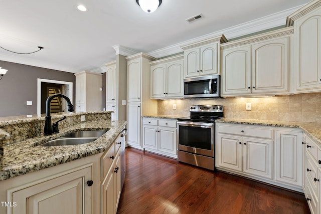 3628 Eagle Farm Dr N, Wilson, NC 27896 - kitchen featuring stainless steel appliances, a sink, cream cabinets, dark wood-style floors, and decorative backsplash