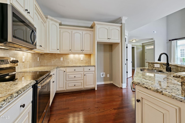 3628 Eagle Farm Dr N, Wilson, NC 27896 - kitchen featuring appliances with stainless steel finishes, a sink, cream cabinetry, dark wood-style floors, and light stone counters