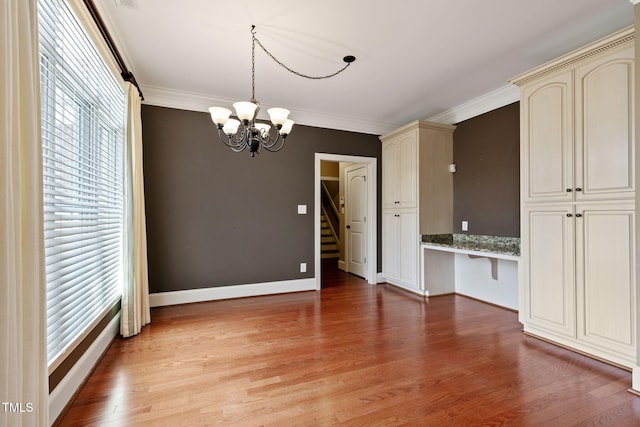3628 Eagle Farm Dr N, Wilson, NC 27896 - unfurnished dining area with healthy amount of natural light, ornamental molding, a chandelier, light wood finished floors, and stairs