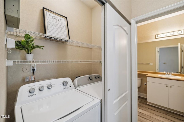 1912 Parkside Village Dr, Clayton, NC 27520 - laundry room with light wood-style flooring, separate washer and dryer, and a textured wall