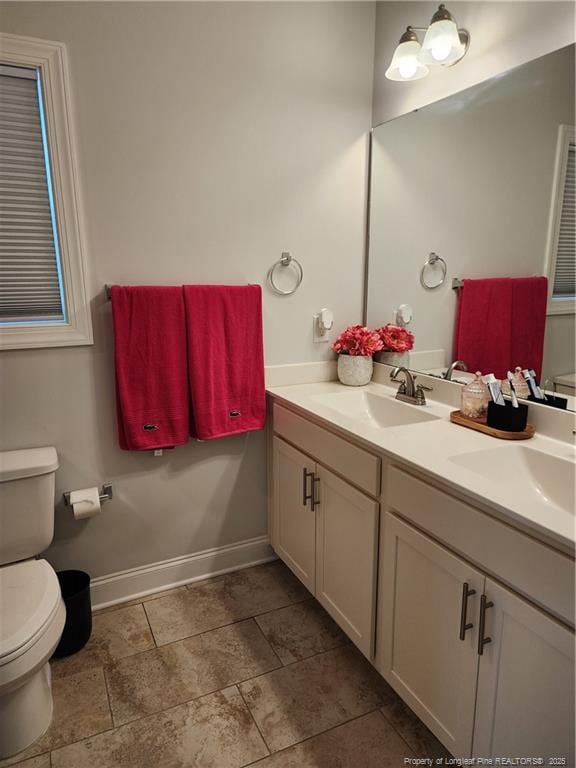 207 Southwick Ct, Sanford, NC 27332 - bathroom with toilet, double vanity, and baseboards