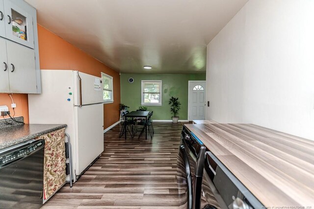 2327 Dewitt St, Sanford, NC 27330 - kitchen with dishwasher, wood finished floors, freestanding refrigerator, dark countertops, and baseboards