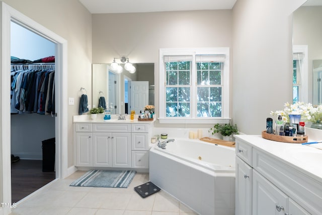 116 Hamilton Hedge Pl, Cary, NC 27519 - bathroom featuring two vanities, a tub with jets, tile patterned floors, and a walk in closet