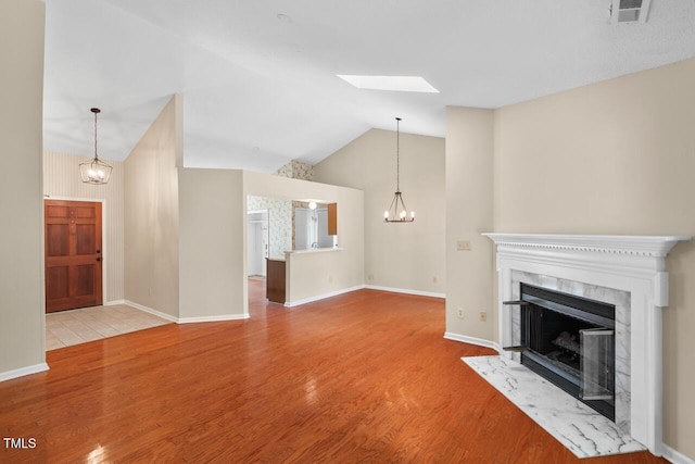 1014 Laurens Way, Knightdale, NC 27545 - unfurnished living room with wood finished floors, a chandelier, a fireplace, vaulted ceiling, and baseboards