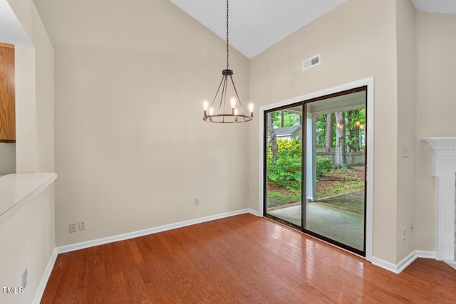 1014 Laurens Way, Knightdale, NC 27545 - unfurnished dining area with a chandelier, wood finished floors, high vaulted ceiling, and baseboards