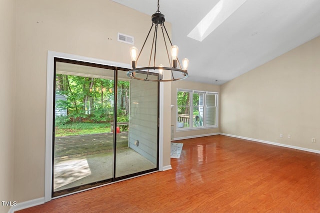 1014 Laurens Way, Knightdale, NC 27545 - empty room with a chandelier, vaulted ceiling, wood finished floors, a skylight, and baseboards