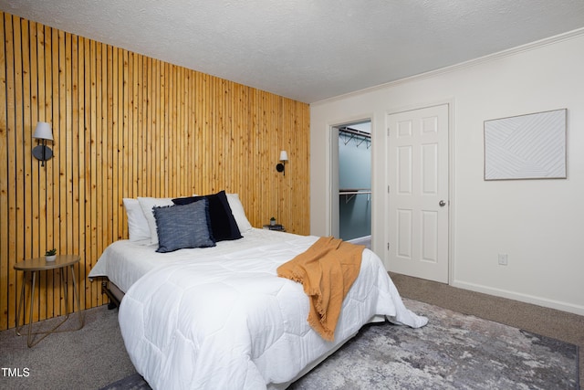 657 Lakeview Dr, Stem, NC 27581 - carpeted bedroom featuring wood walls, a walk in closet, a closet, and ornamental molding