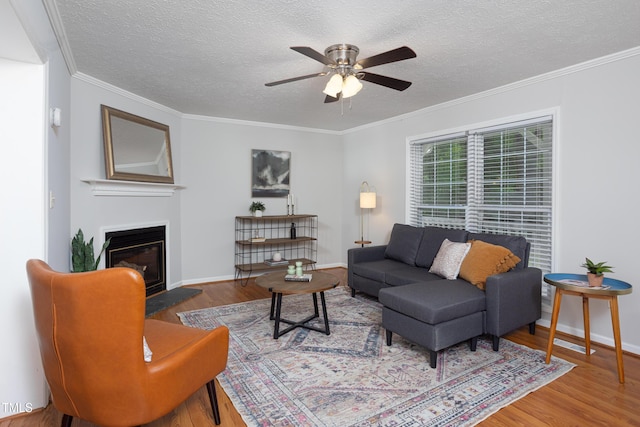 657 Lakeview Dr, Stem, NC 27581 - living room with wood finished floors, a ceiling fan, a glass covered fireplace, a textured ceiling, and crown molding