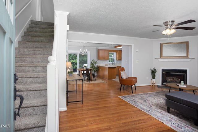 657 Lakeview Dr, Stem, NC 27581 - living room featuring light wood-style flooring, stairway, crown molding, a ceiling fan, and a textured ceiling