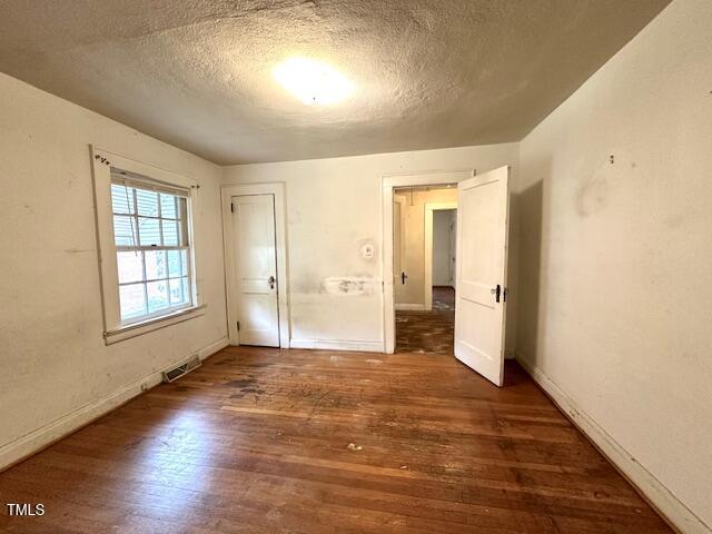 3810 Pendergrass St, Durham, NC 27704 - unfurnished room featuring a textured ceiling, wood finished floors, and baseboards