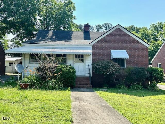 3810 Pendergrass St, Durham, NC 27704 - bungalow-style home with a front lawn, entry steps, a chimney, and brick siding