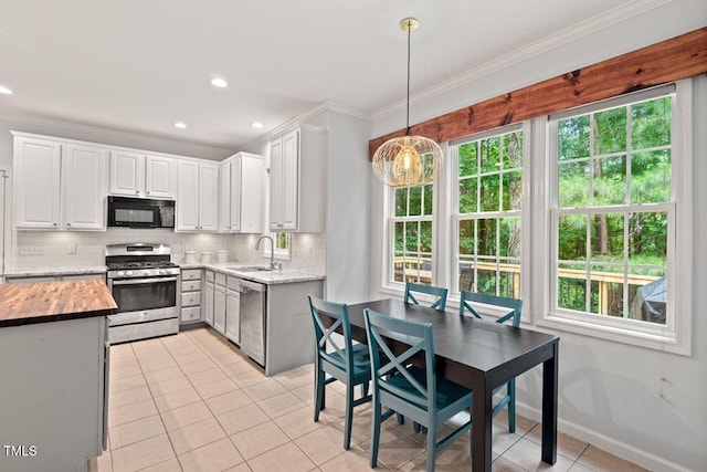 5 Providence Ridge Ln, Durham, NC 27713 - kitchen with stainless steel appliances, a sink, ornamental molding, light tile patterned floors, and backsplash