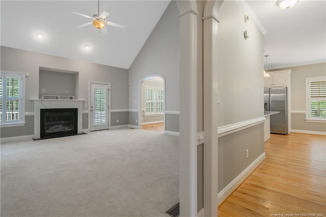 45 Remington Hills Dr, Bunnlevel, NC 28323 - unfurnished living room featuring a ceiling fan, baseboards, a fireplace with flush hearth, arched walkways, and high vaulted ceiling