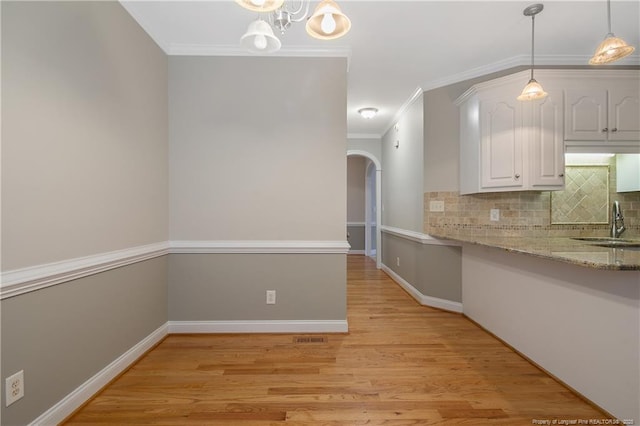 45 Remington Hills Dr, Bunnlevel, NC 28323 - kitchen with crown molding, a sink, white cabinets, light wood-type flooring, and decorative backsplash