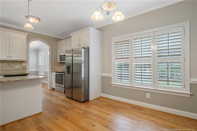 45 Remington Hills Dr, Bunnlevel, NC 28323 - kitchen featuring stainless steel appliances, arched walkways, tasteful backsplash, decorative light fixtures, and light wood-type flooring