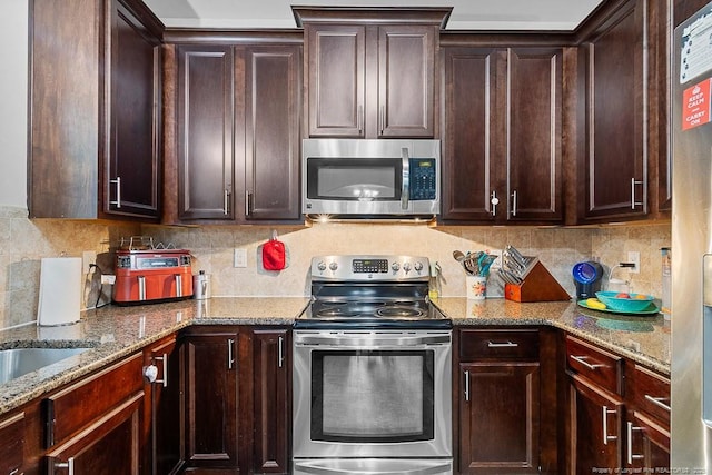 265 Tactical Dr, Bunnlevel, NC 28323 - kitchen with stainless steel appliances, tasteful backsplash, dark brown cabinetry, and light stone counters