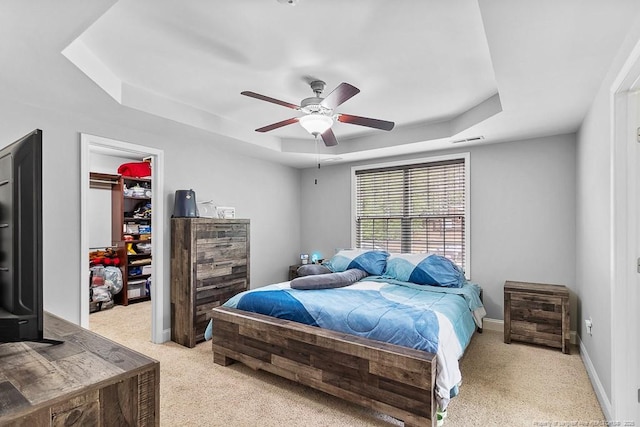 265 Tactical Dr, Bunnlevel, NC 28323 - bedroom with a tray ceiling, a spacious closet, light colored carpet, a closet, and baseboards