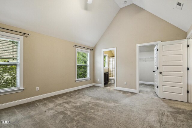 347 Country Mill Way, Fuquay Varina, NC 27526 - unfurnished bedroom with a walk in closet, carpet flooring, baseboards, ensuite bathroom, and high vaulted ceiling