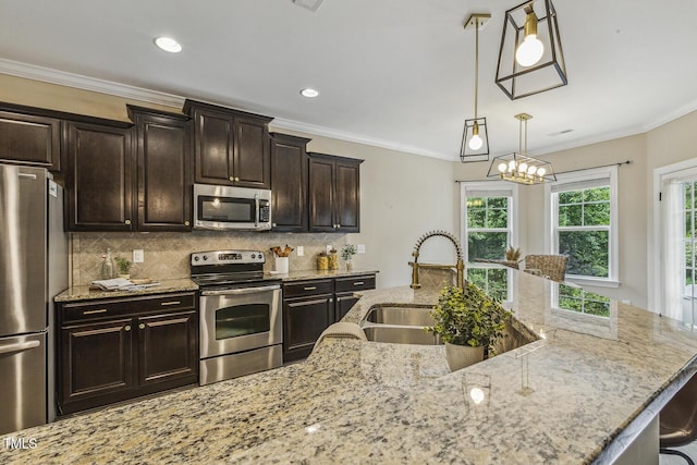 347 Country Mill Way, Fuquay Varina, NC 27526 - kitchen featuring stainless steel appliances, a sink, light stone counters, tasteful backsplash, and decorative light fixtures