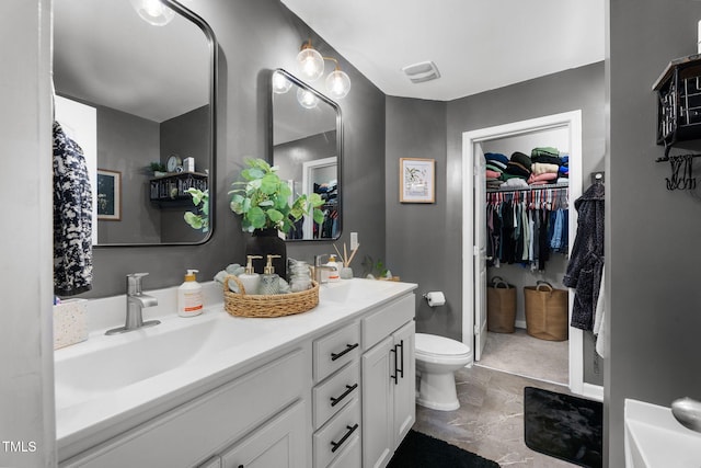 7807 Elmshire Way, Raleigh, NC 27616 - bathroom featuring double vanity, toilet, and a walk in closet