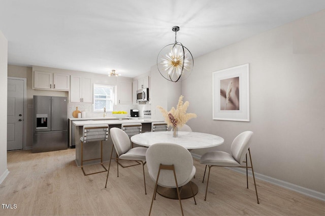 391 E Williams St, Angier, NC 27501 - dining area featuring light wood-type flooring, baseboards, and a chandelier