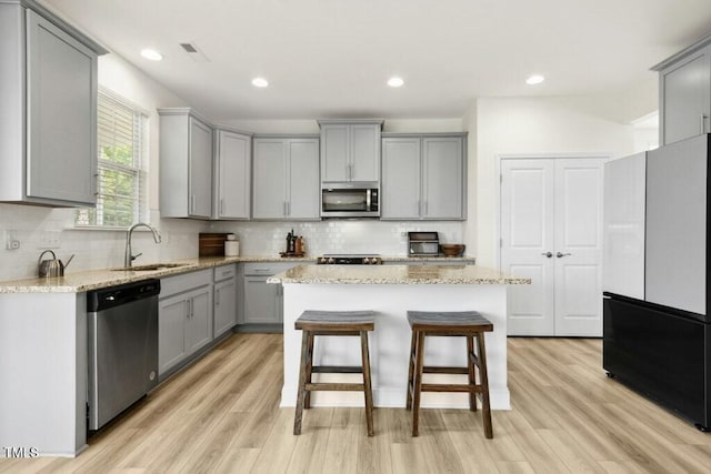 116 Hayfield Dr, Lillington, NC 27546 - kitchen featuring gray cabinetry, stainless steel appliances, a sink, light wood-type flooring, and recessed lighting