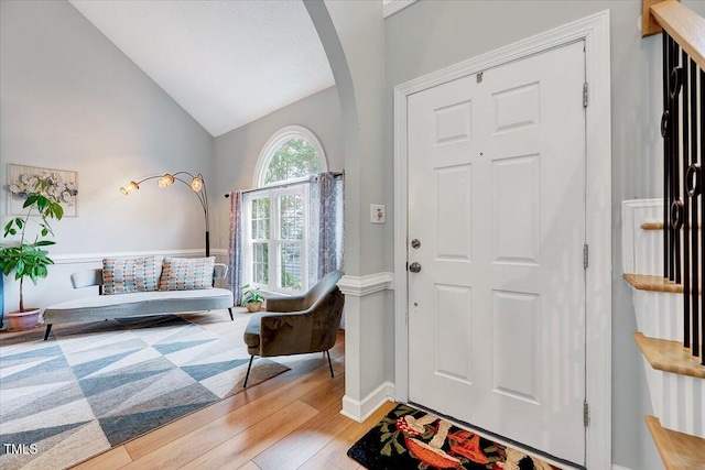 113 Fetzer Ct, Cary, NC 27513 - foyer featuring wood finished floors, arched walkways, baseboards, and high vaulted ceiling