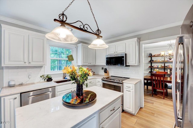 113 Fetzer Ct, Cary, NC 27513 - kitchen featuring stainless steel appliances, white cabinets, crown molding, decorative backsplash, and light wood-style floors
