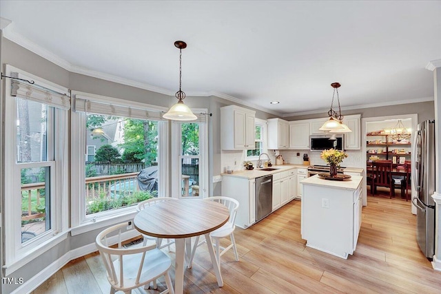 113 Fetzer Ct, Cary, NC 27513 - kitchen with appliances with stainless steel finishes, light countertops, healthy amount of natural light, backsplash, and crown molding
