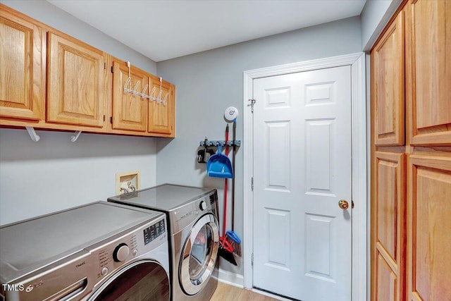 113 Fetzer Ct, Cary, NC 27513 - laundry room featuring independent washer and dryer, cabinet space, and light wood-style flooring