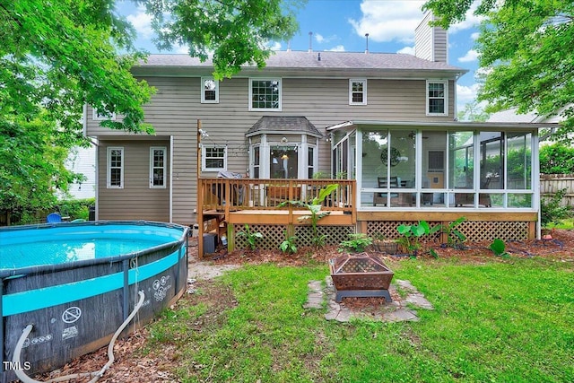 113 Fetzer Ct, Cary, NC 27513 - back of property featuring a sunroom, a chimney, a lawn, and a wooden deck