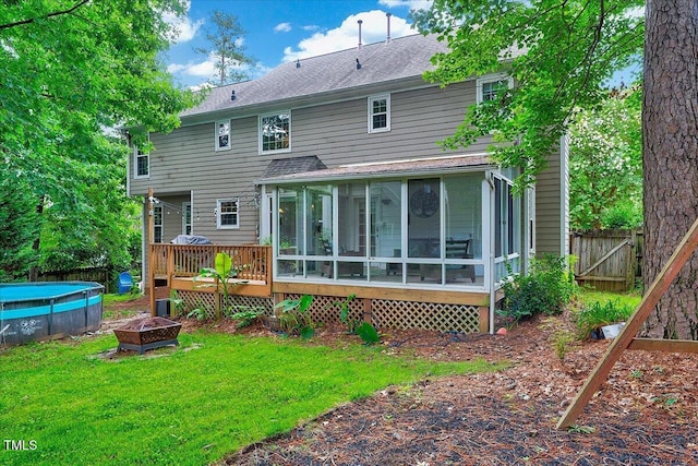 113 Fetzer Ct, Cary, NC 27513 - rear view of property with a sunroom, an outdoor pool, a fire pit, a wooden deck, and roof with shingles