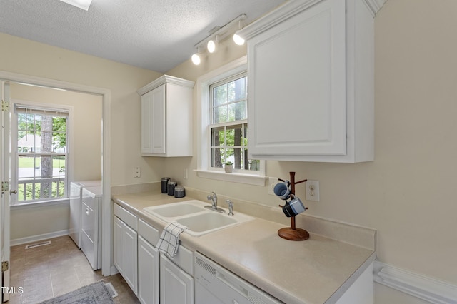 118 Setter Pt, Clayton, NC 27520 - kitchen with a sink, separate washer and dryer, dishwasher, white cabinetry, and light countertops