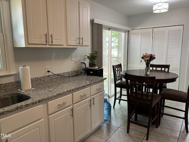 503 Pine Run, Knightdale, NC 27545 - kitchen with light tile patterned floors, white cabinetry, light stone countertops, and a sink