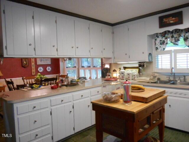 6517 Whitted Rd, Fuquay Varina, NC 27526 - kitchen with light countertops, a sink, white cabinetry, and dishwasher