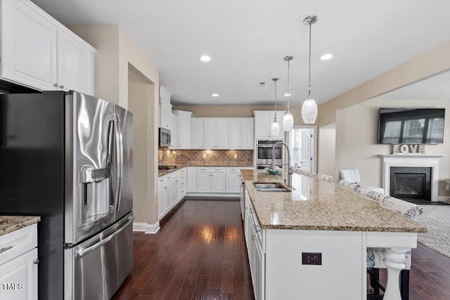2333 Lantern Walk Ln, Wake Forest, NC 27587 - kitchen with appliances with stainless steel finishes, a sink, dark wood-style floors, a breakfast bar, and tasteful backsplash