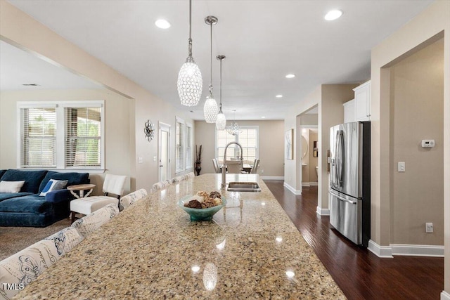 2333 Lantern Walk Ln, Wake Forest, NC 27587 - kitchen with stainless steel fridge, a sink, a chandelier, open floor plan, and white cabinetry