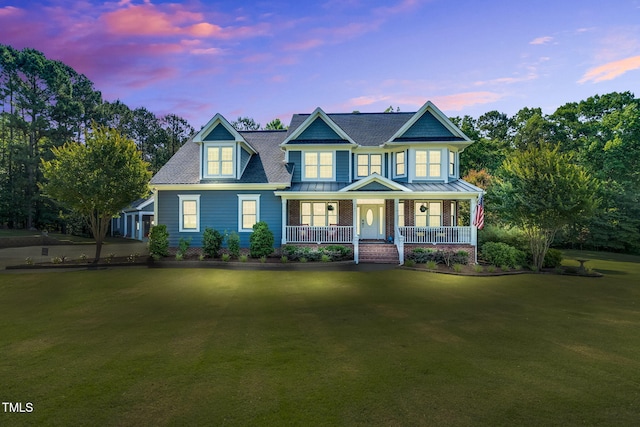 227 Paraggi Ct, Clayton, NC 27527 - view of front of home with a porch, a front yard, a standing seam roof, and metal roof
