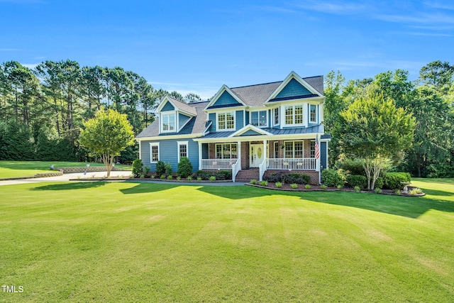 227 Paraggi Ct, Clayton, NC 27527 - view of front of property featuring covered porch, a standing seam roof, a front lawn, metal roof, and roof with shingles