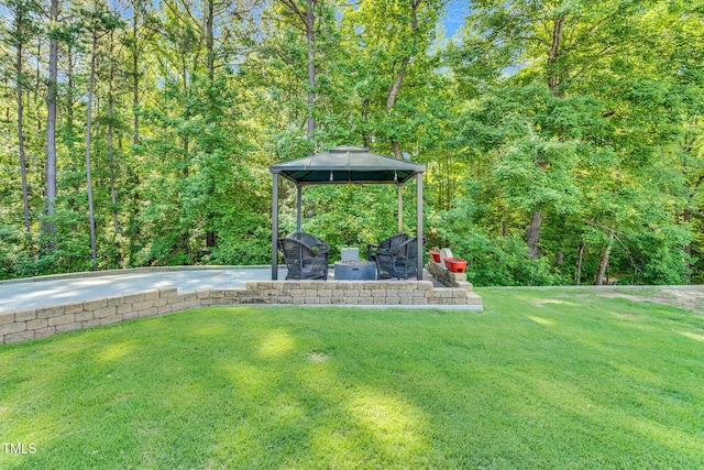 227 Paraggi Ct, Clayton, NC 27527 - view of grassy yard with a gazebo, concrete driveway, a patio, and a forest view