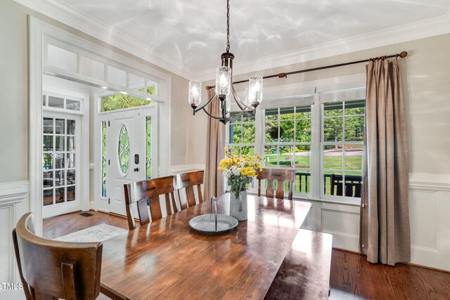 227 Paraggi Ct, Clayton, NC 27527 - dining area with a chandelier, wood finished floors, plenty of natural light, a decorative wall, and crown molding