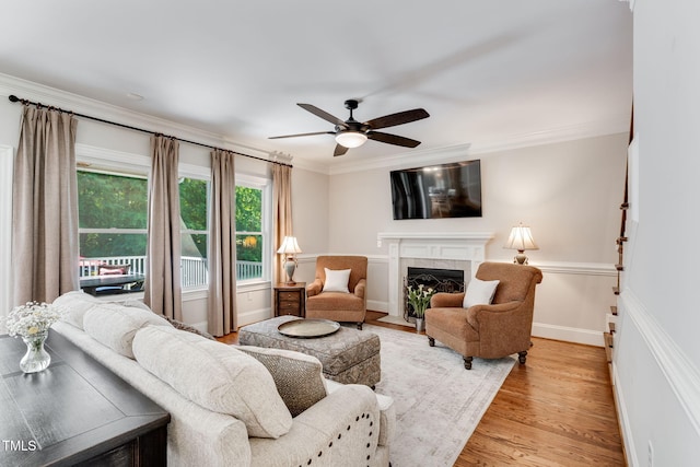 227 Paraggi Ct, Clayton, NC 27527 - living area featuring crown molding, a ceiling fan, a tile fireplace, light wood-style floors, and baseboards