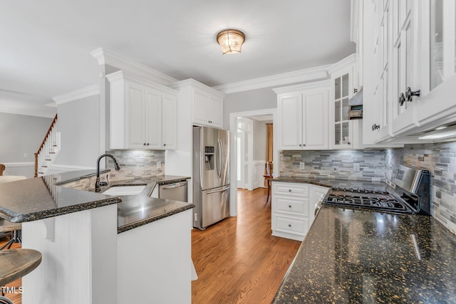 227 Paraggi Ct, Clayton, NC 27527 - kitchen with stainless steel appliances, ornamental molding, a peninsula, a sink, and decorative backsplash