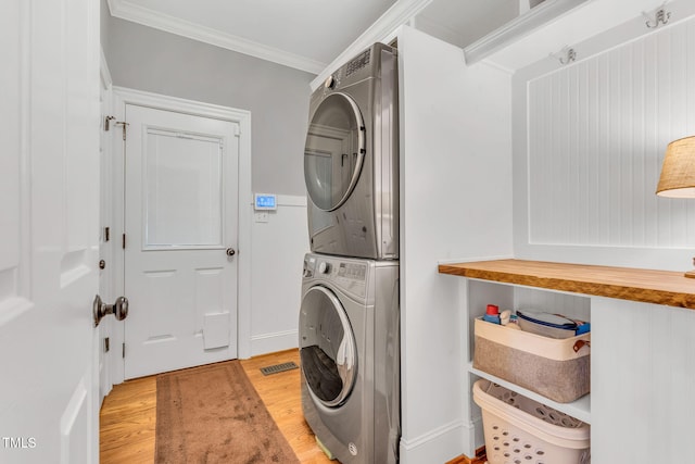 227 Paraggi Ct, Clayton, NC 27527 - laundry room featuring stacked washing machine and dryer, light wood finished floors, ornamental molding, and baseboards