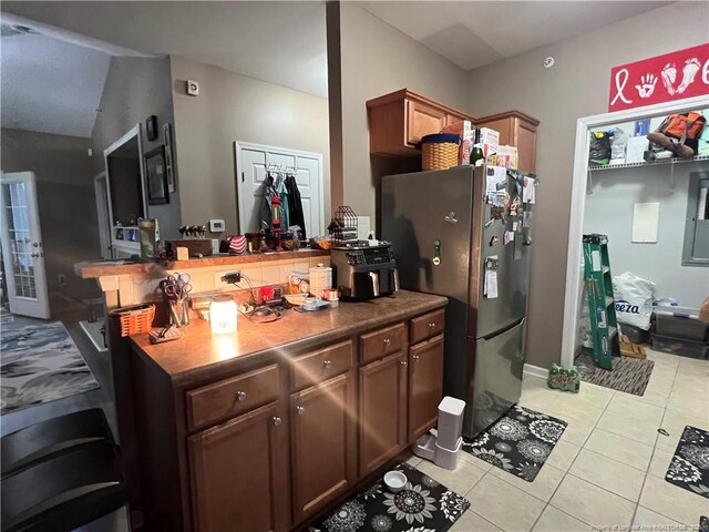 621 Marshtree Ln Unit 303, Fayetteville, NC 28314 - kitchen featuring freestanding refrigerator, light tile patterned floors, and a peninsula