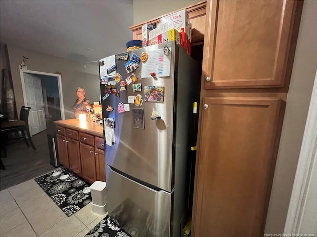 621 Marshtree Ln Unit 303, Fayetteville, NC 28314 - kitchen featuring freestanding refrigerator, light tile patterned flooring, light countertops, and brown cabinetry