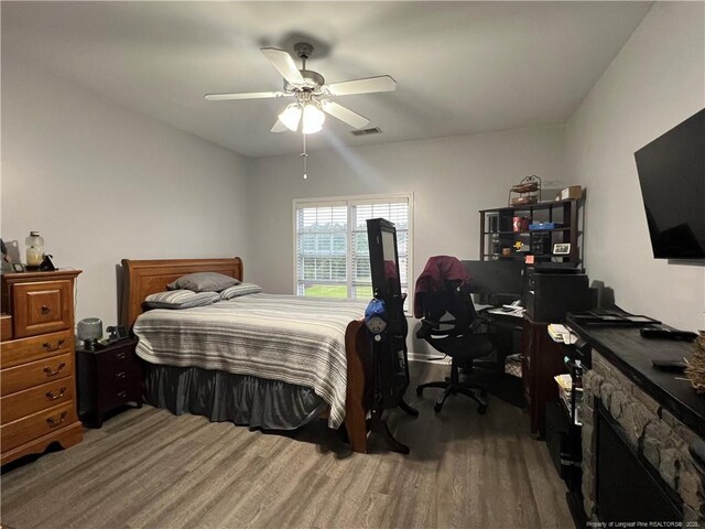 621 Marshtree Ln Unit 303, Fayetteville, NC 28314 - bedroom featuring wood finished floors, ceiling fan, and a stone fireplace