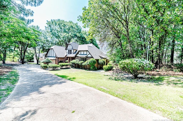 259 Golf Dr, Sanford, NC 27332 - tudor home with a front lawn, brick siding, and concrete driveway