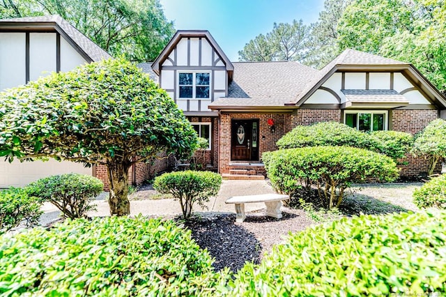 259 Golf Dr, Sanford, NC 27332 - tudor house featuring brick siding, roof with shingles, and a garage