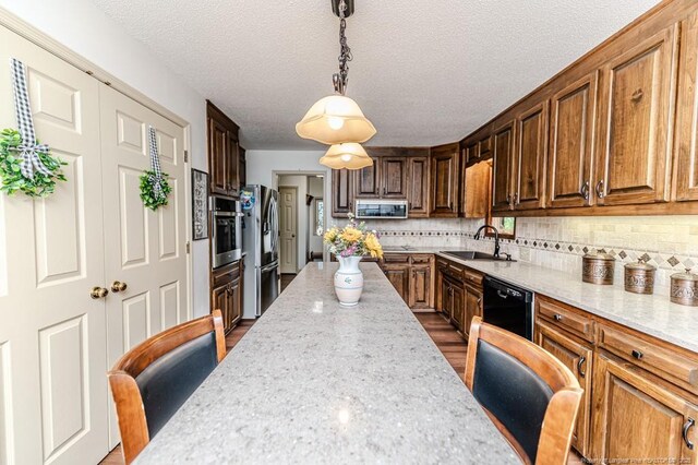 259 Golf Dr, Sanford, NC 27332 - kitchen featuring appliances with stainless steel finishes, a sink, light stone counters, tasteful backsplash, and a textured ceiling